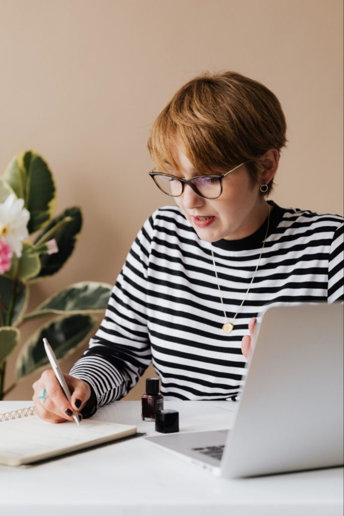 Woman writing in notepad about poor management